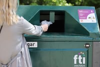 Woman recycling in FTI återvinnare bin.