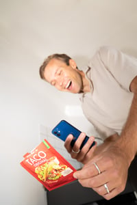 Happy man with phone scanning packaging.